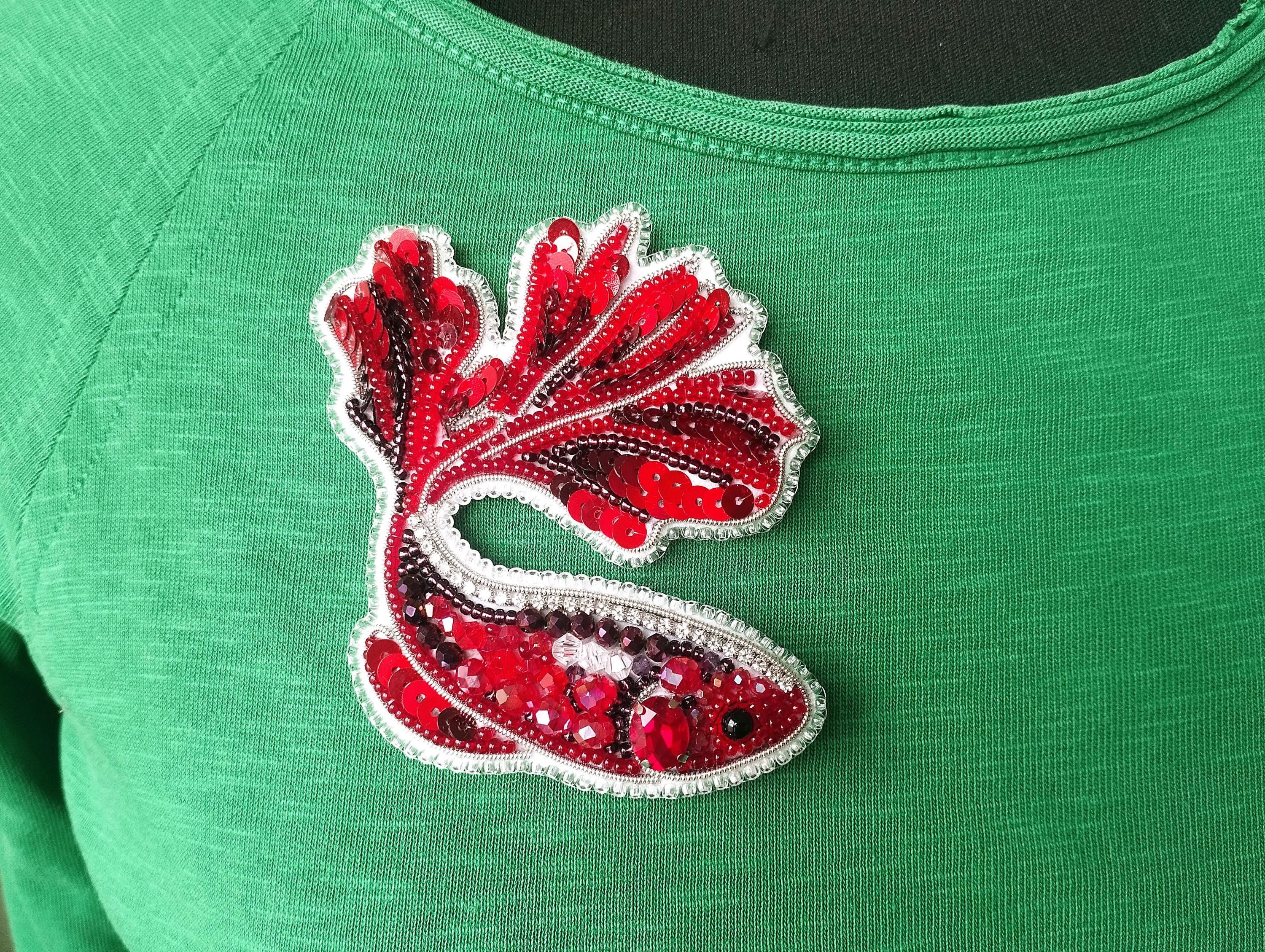 a green shirt with red and white sequins on it